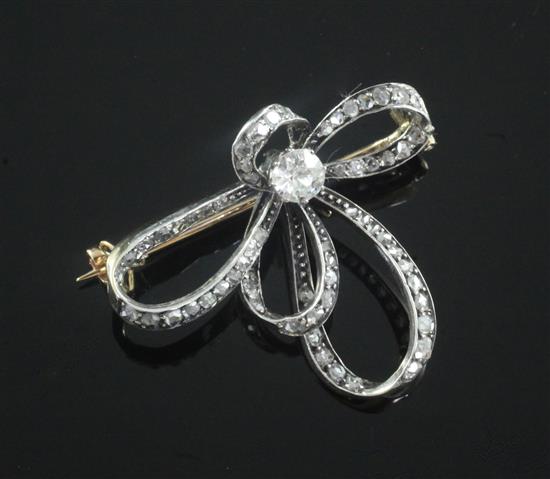 An Edwardian gold, silver and diamond scroll brooch, 35mm.